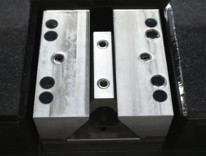 Close-up photograph of a slip-table inverted-V guideway. Representative catalog photograph.